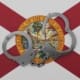 A pair of silver handcuffs is placed on the Florida State flag, which features a red cross on a white background with the Florida state seal at the center. The seal depicts a Native American, a steamboat, a cabbage palmetto tree, and the sun.